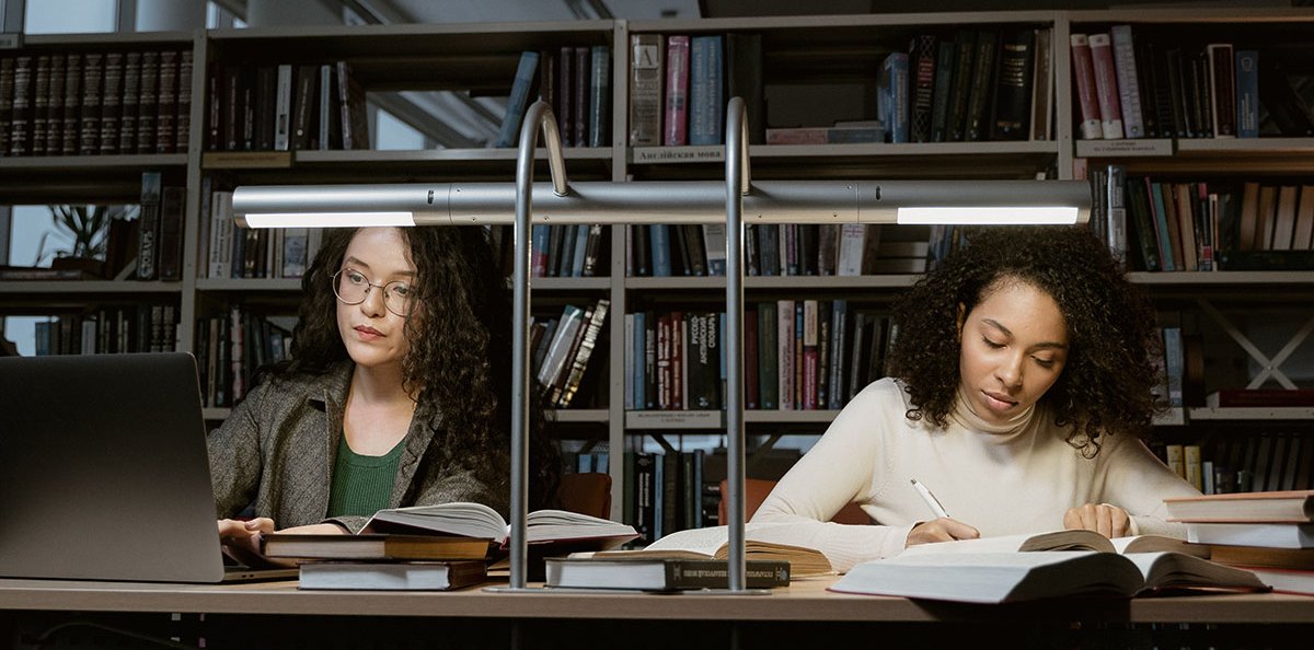 Two people working at a library table