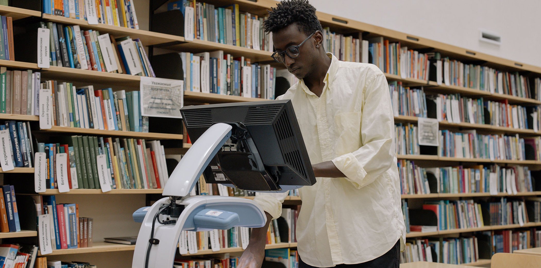 Un home fent servir un escàner a una biblioteca