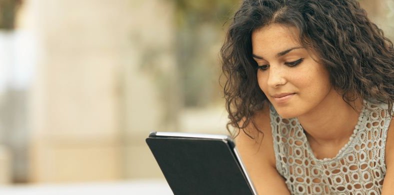 Una mujer leyendo la pantalla de una tablet