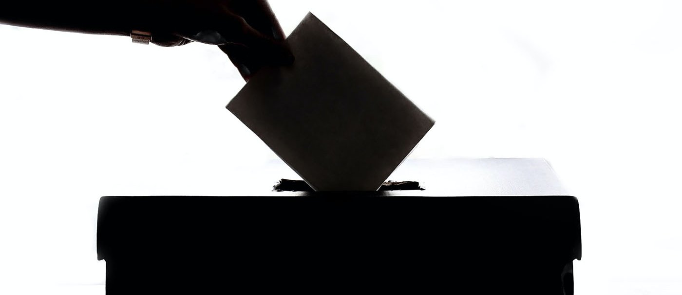 Una persona introduint un vot a una urna