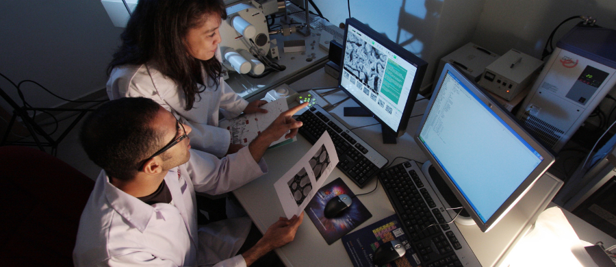 Una investigadora y un investigador mirando un artículo en el ordenador