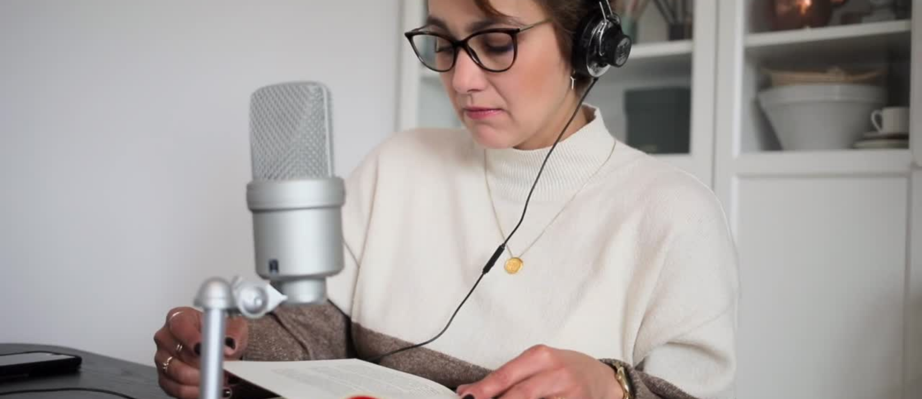  Una mujer leyendo un texto con un micrófono y auriculares