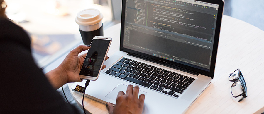 A person using a laptop and a mobile phone (both connected to each other) at the same time