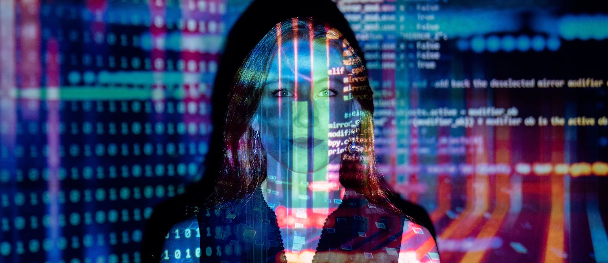 A woman in front of a wall with projections of source code and binary code