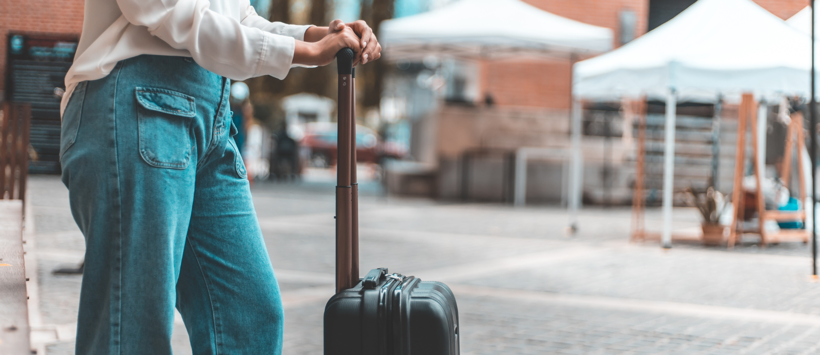 A woman with a suitcase on wheels