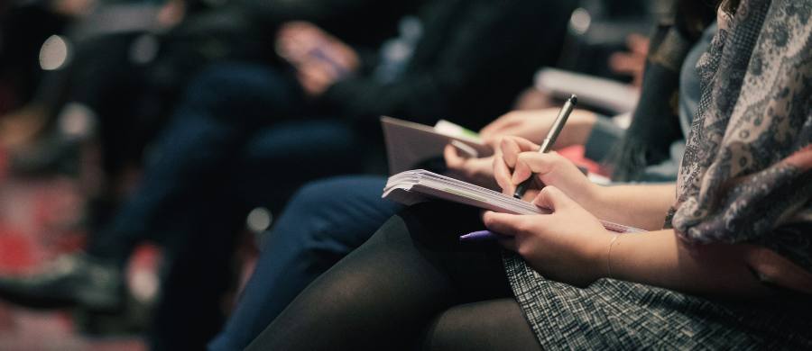 Persones en un congrés prenent anotacions en una llibreta 