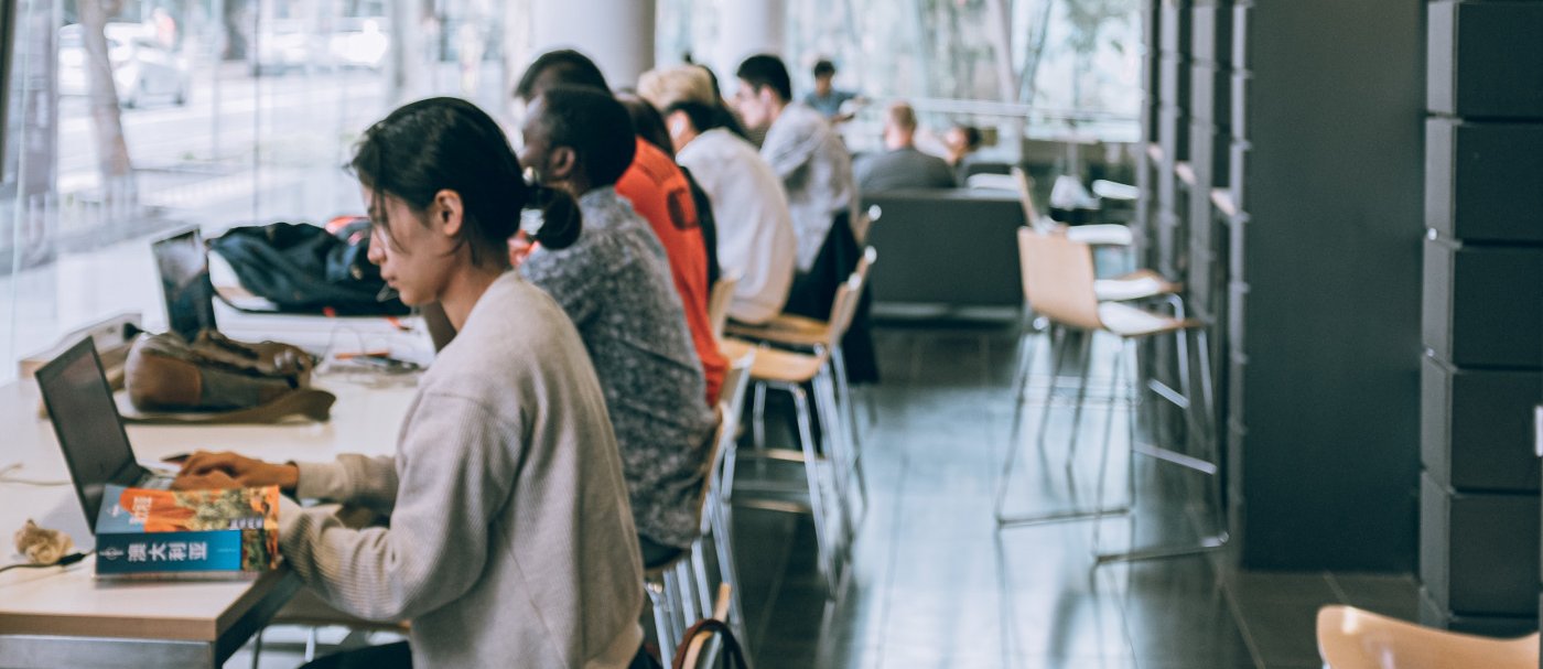 Estudiantes con portátiles en una biblioteca