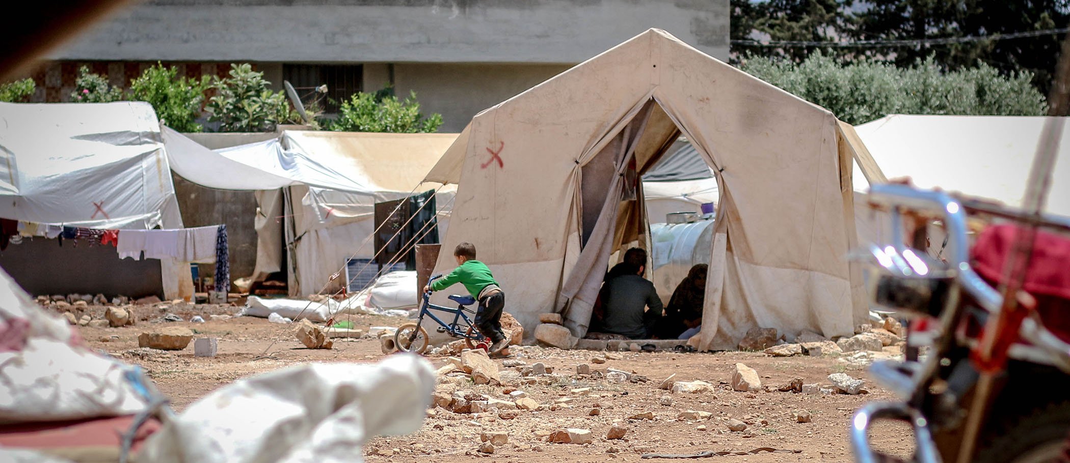 A kid with a bike at a refugee camp