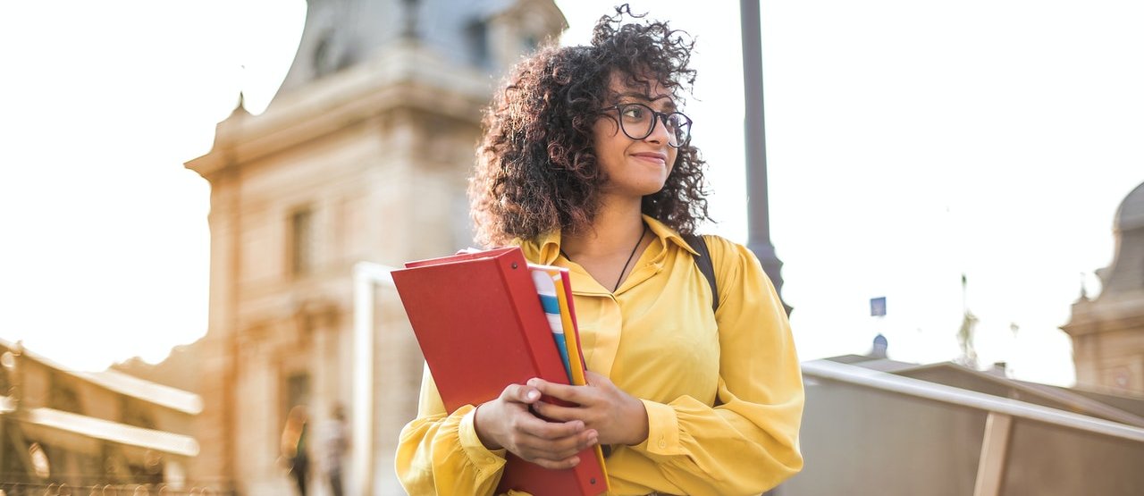 Estudiante con libretas en las manos 