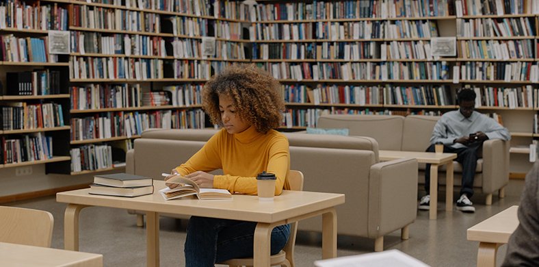 Two people reading and studying inside a library