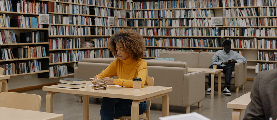 Two people reading and studying inside a library