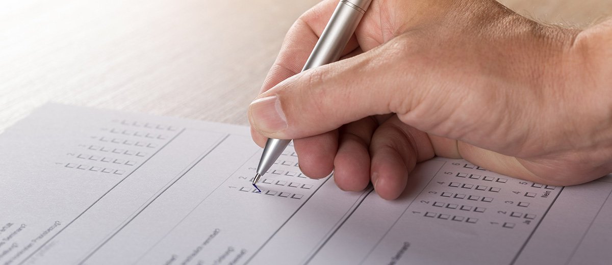 A person filling out a survey on a sheet of paper