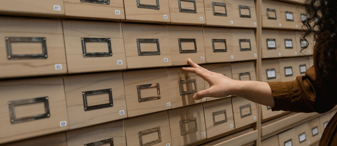 A hand touching a series of filing cabinets