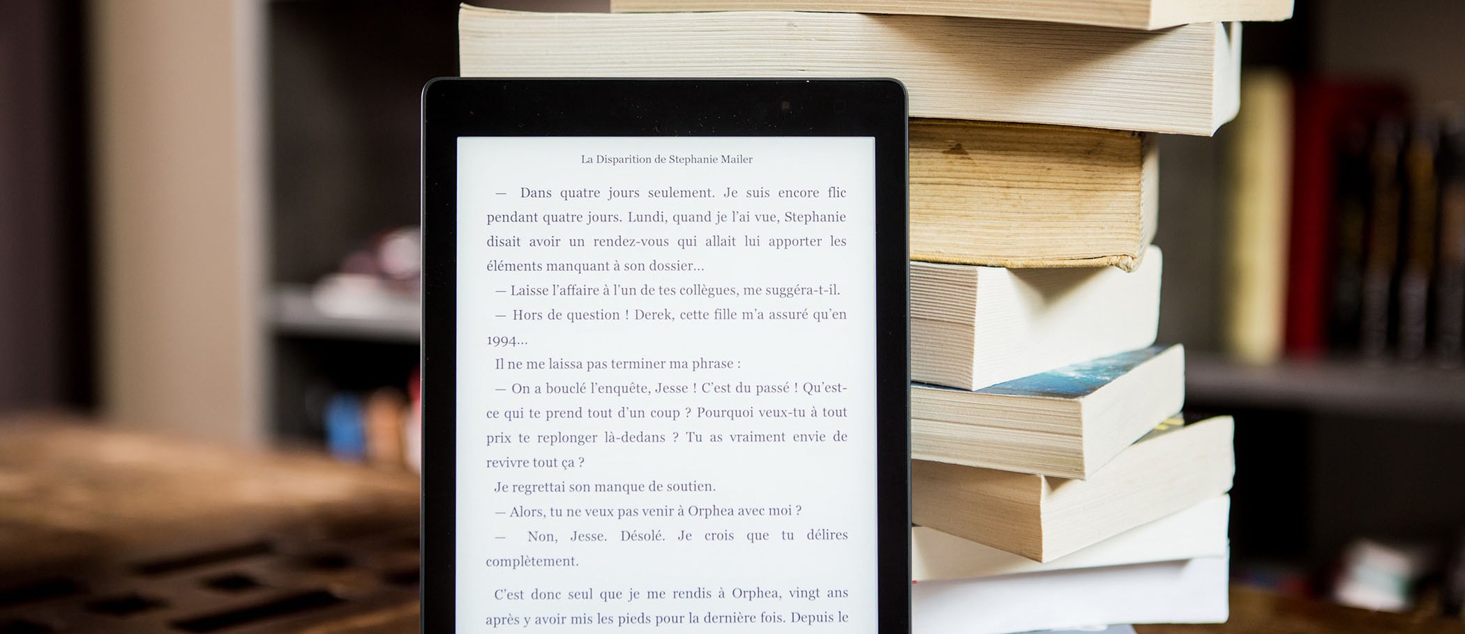 Un ebook al costat d'una torre de llibres