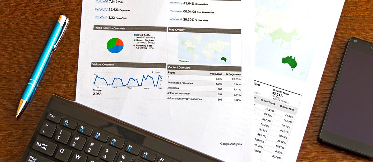 A sheet of paper with statistics next to a pen and a computer keyboard