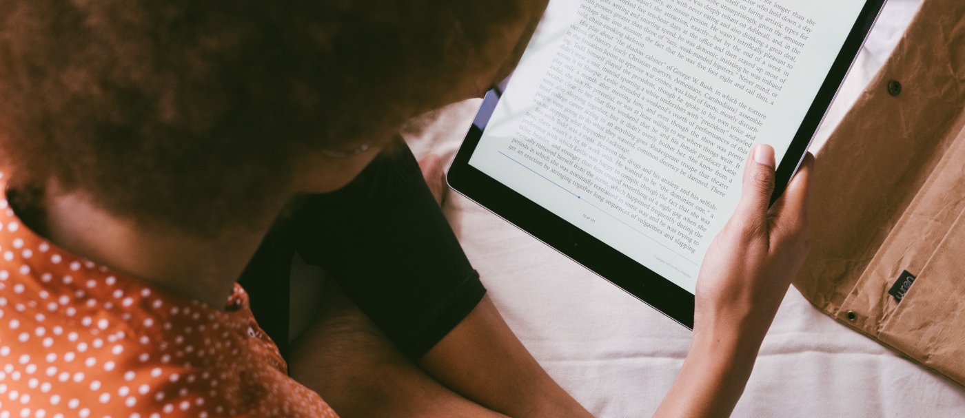 Una mujer leyendo un libro electrónico