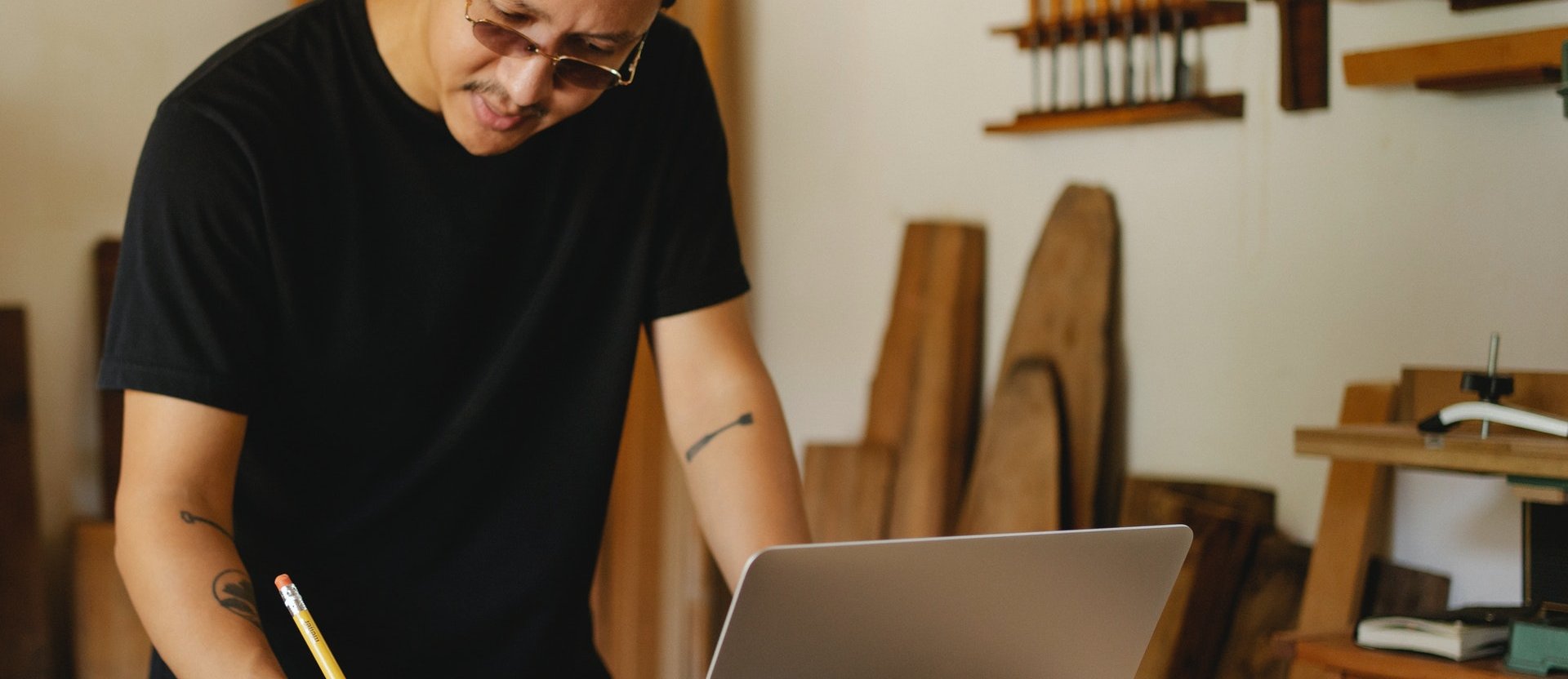 Man taking notes in front of a laptop