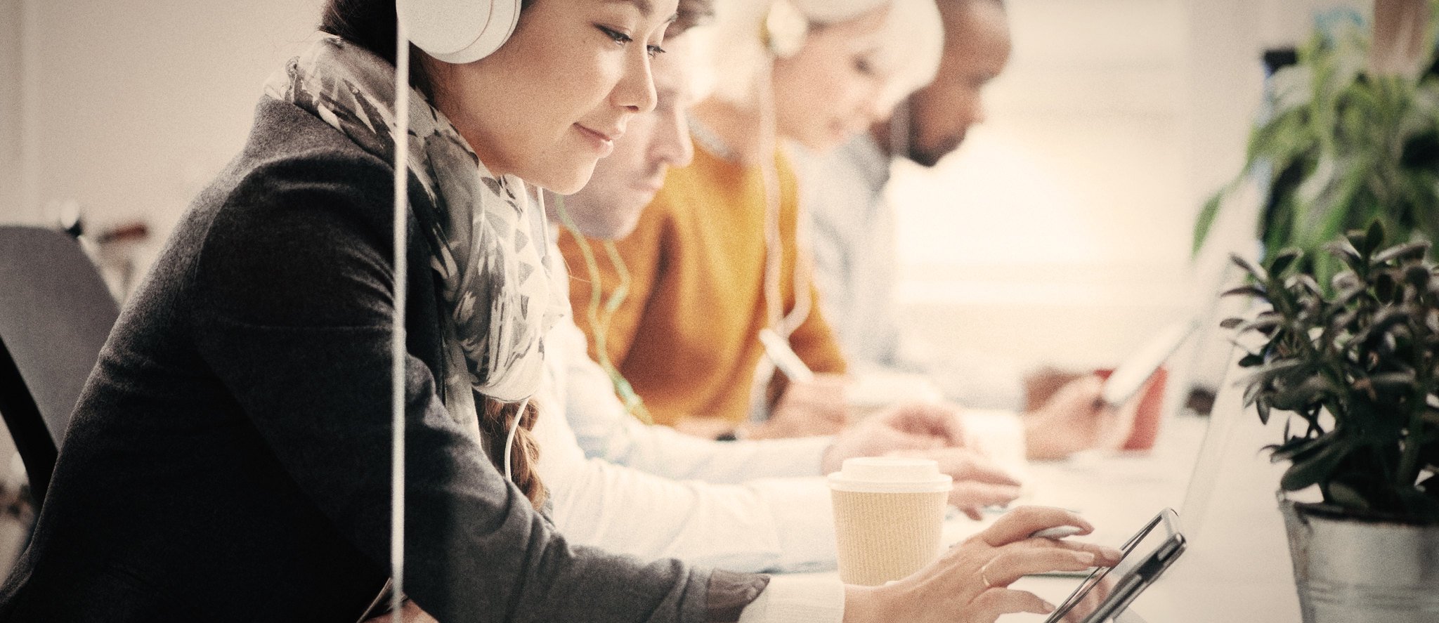 A group of people with tablets and headphones