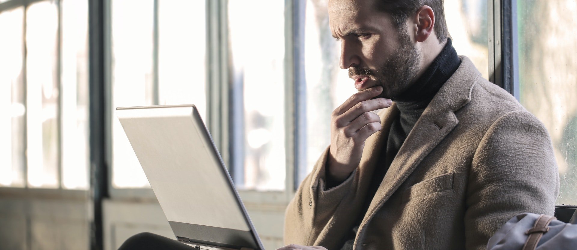 Man thinking in front of laptop 