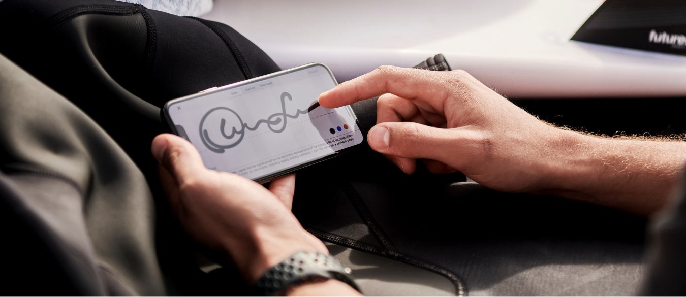 A person signing a document on a mobile phone