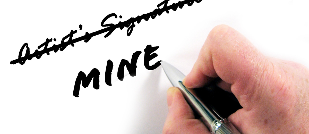 Una mà ratllant "artist's signature" i escribint "mine"