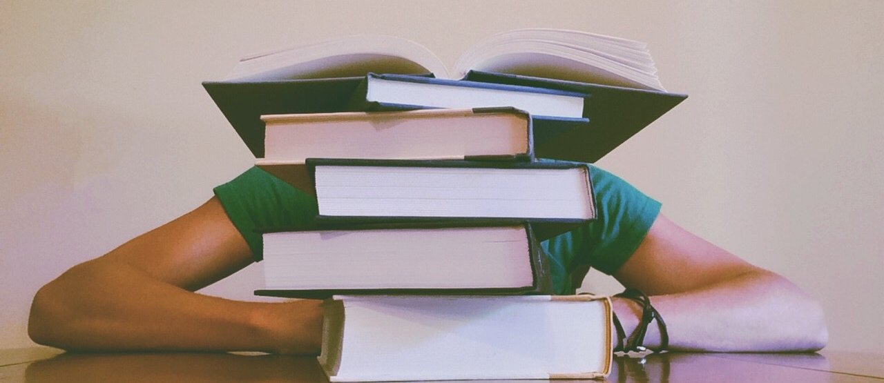 Montaña de libros sobre una mesa