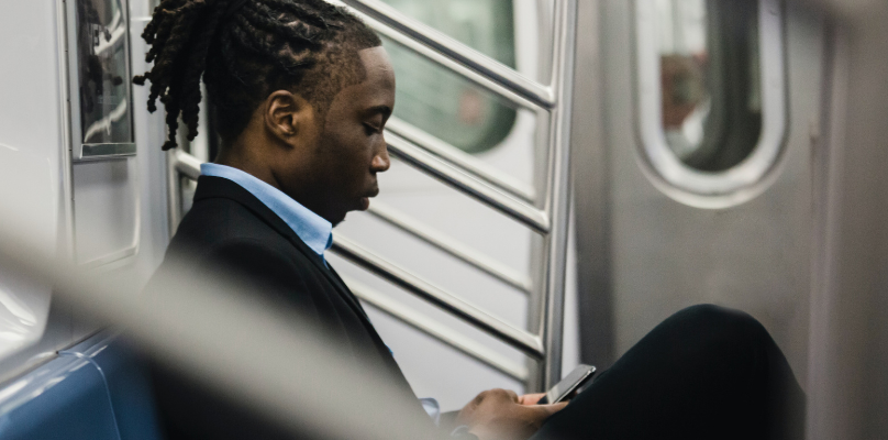 Man consulting a tablet on the subway