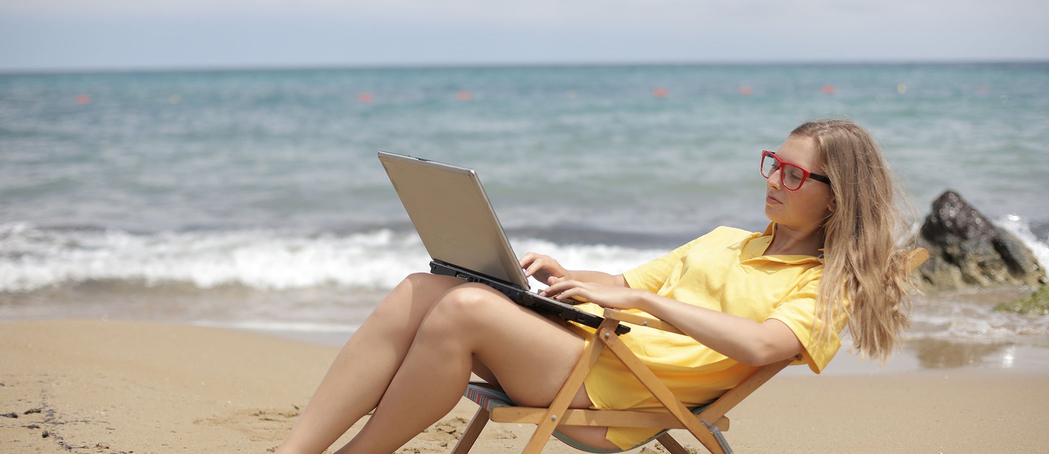 Una mujer utilizando un portátil en la playa
