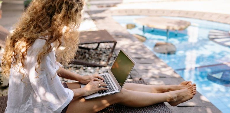 Un noia amb un ordinador a la piscina