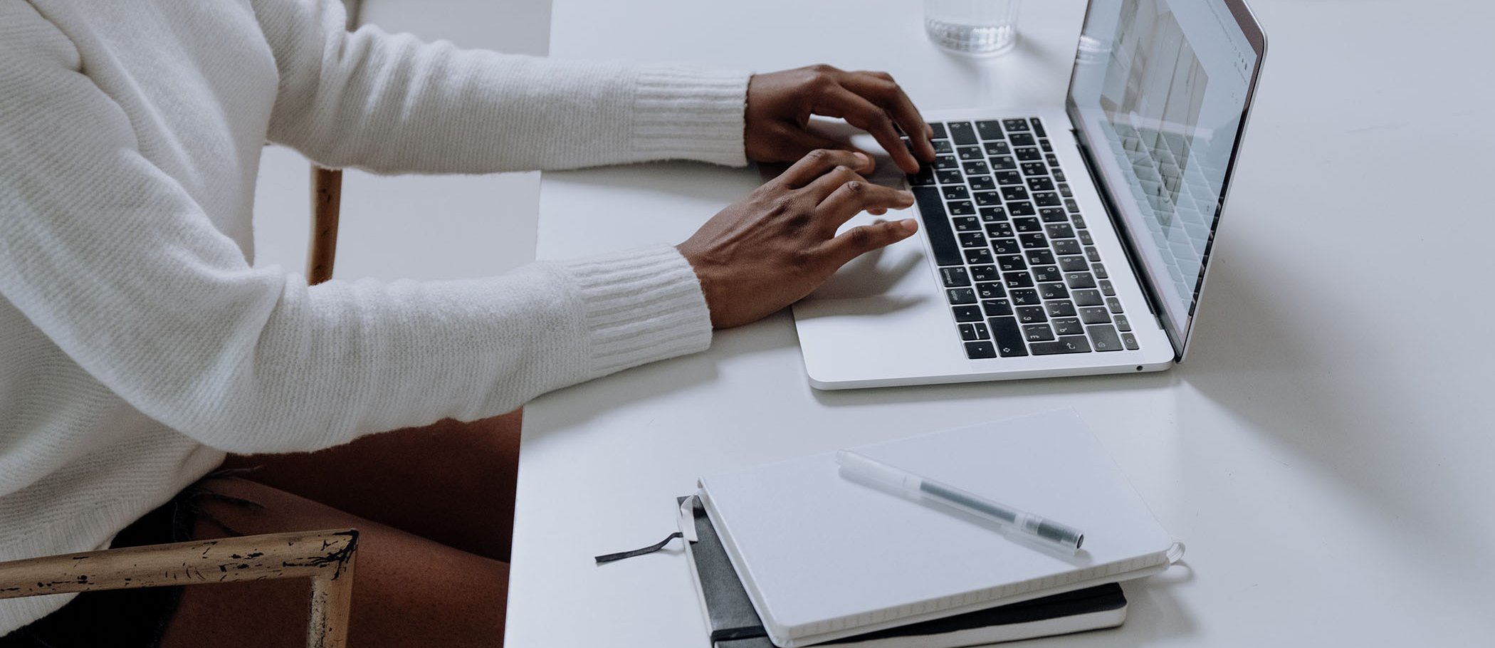 One person writing with a laptop