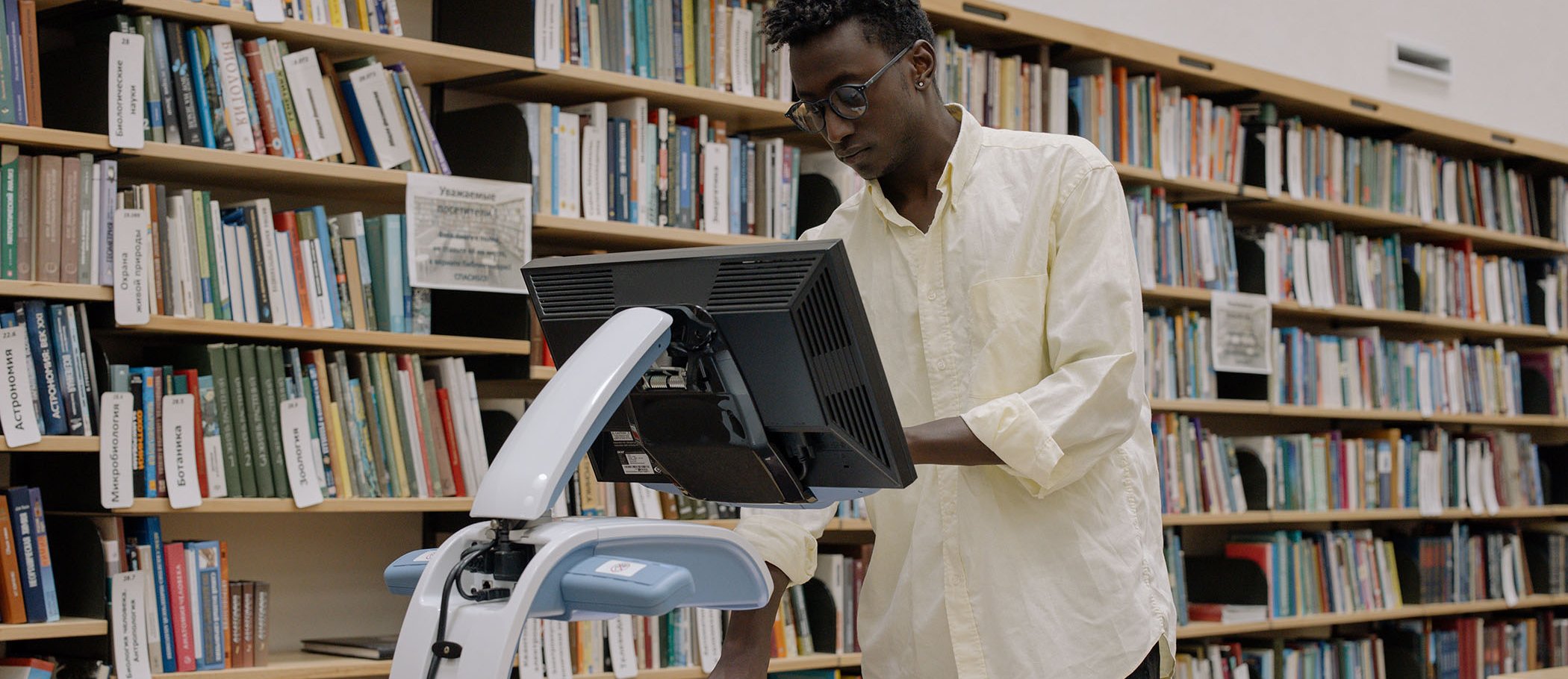 Un home fent servir un escàner a una biblioteca