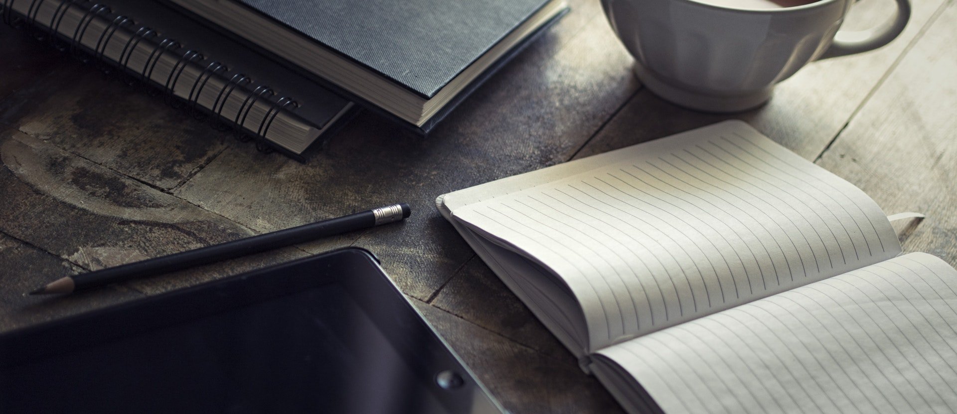 A coffee, a notebook and a tablet