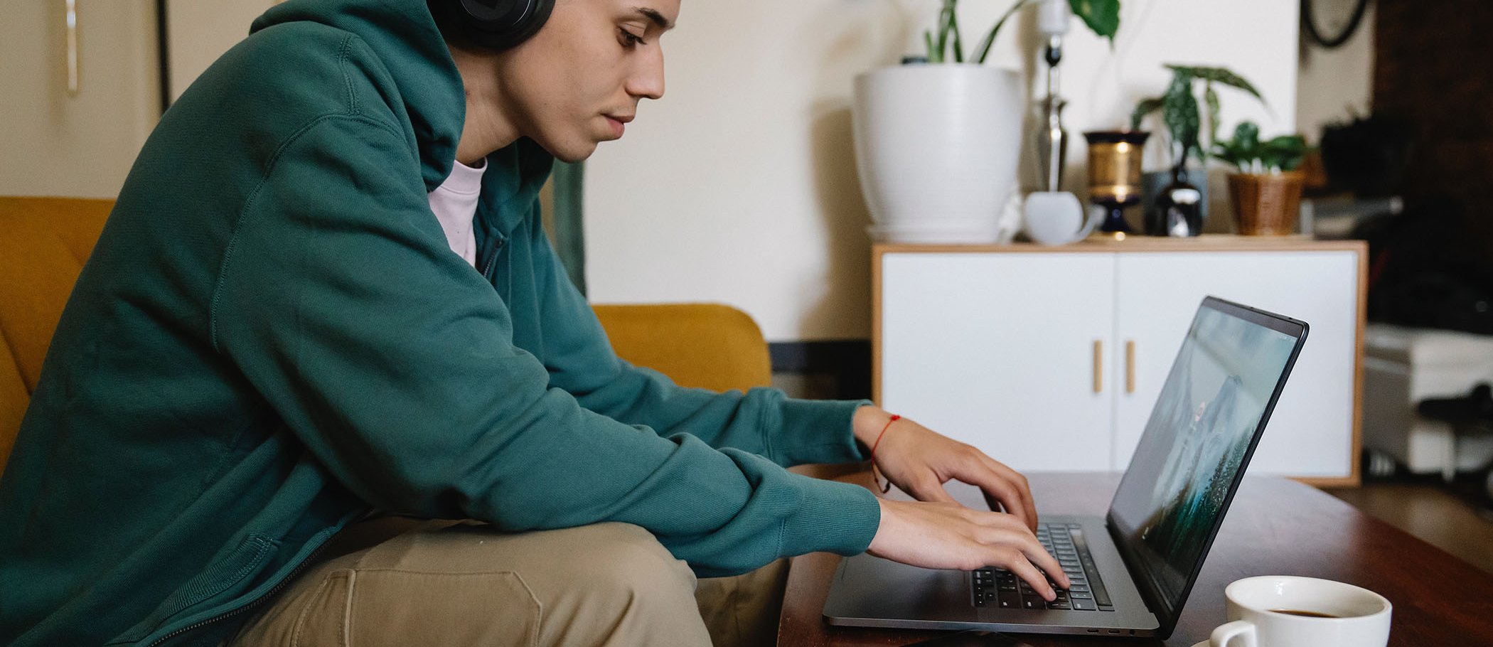 A young man with headphones using a laptop