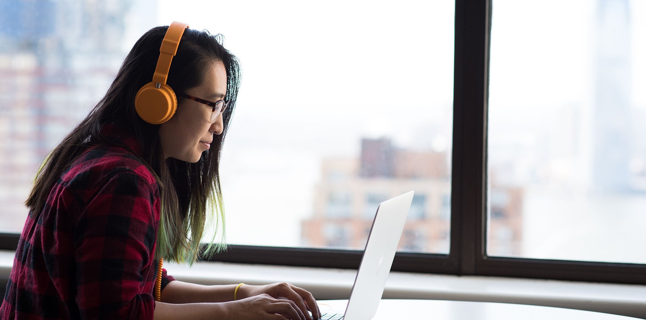 A woman with a laptop and a pair of headphones