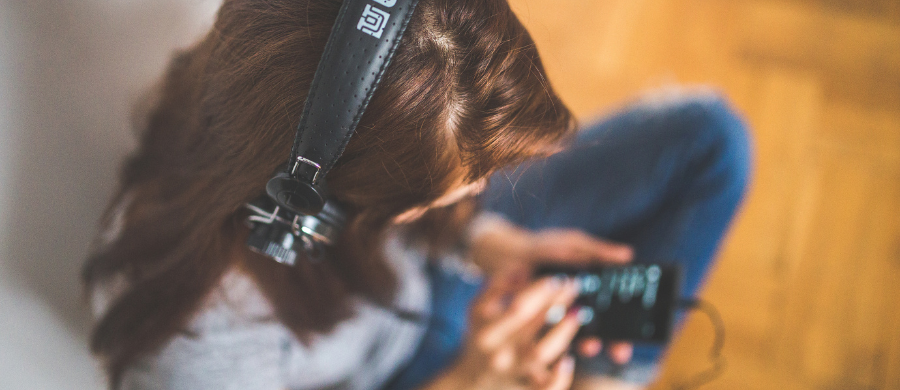 A woman listenning to a video on her mobile phone