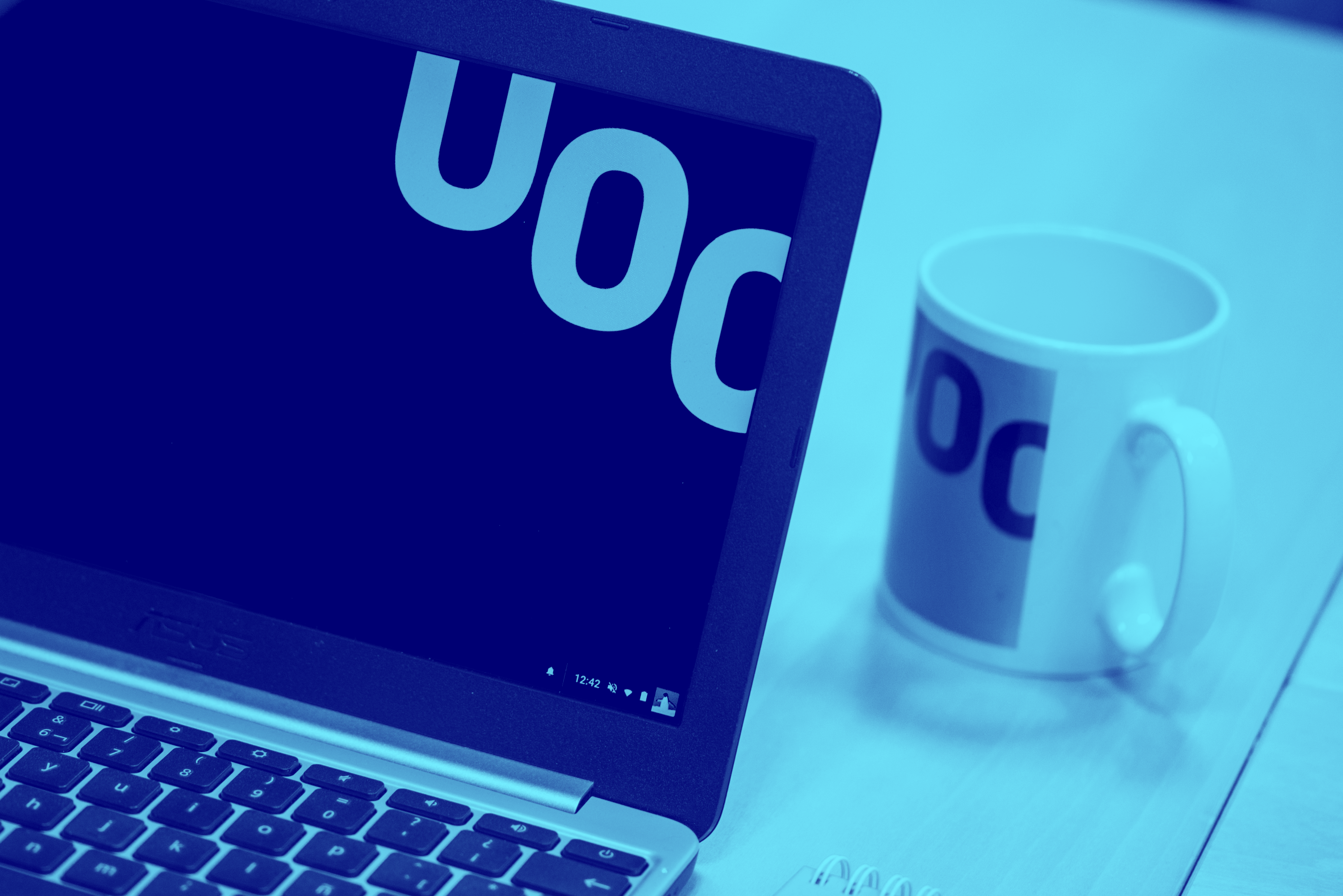 Portàtil i tassa amb marca UOC