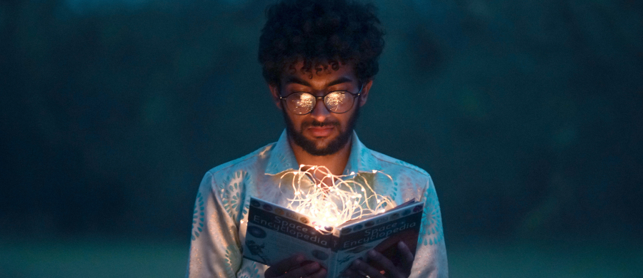 Persona que está leyendo un libro que tiene luces dentro