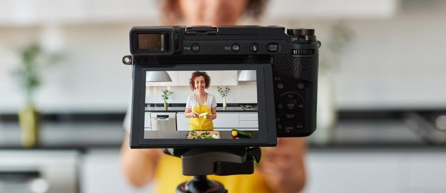 A woman records a video while cooking