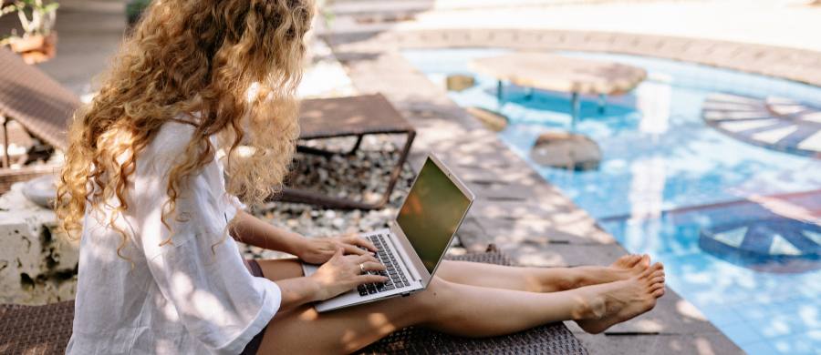 A girl with the computer in the pool