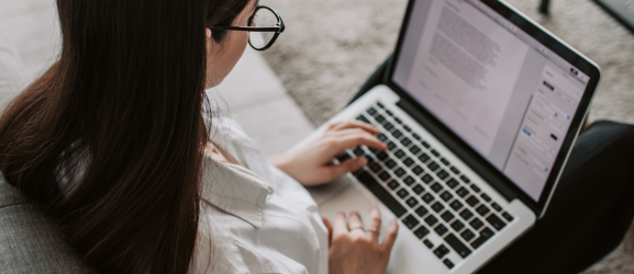 Woman taking notes on laptop