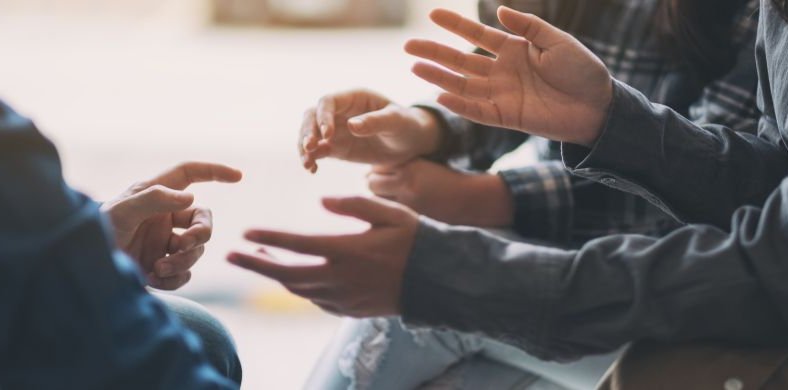 Close-up of the hands of a group of people talking