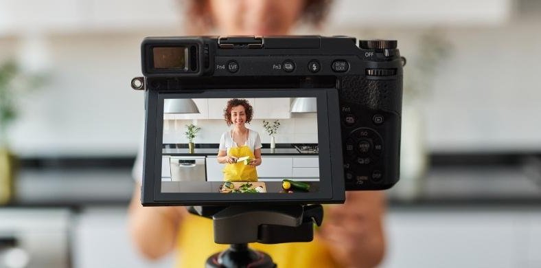 A woman records a video while cooking