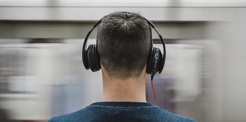 A boy with headphones in the subway
