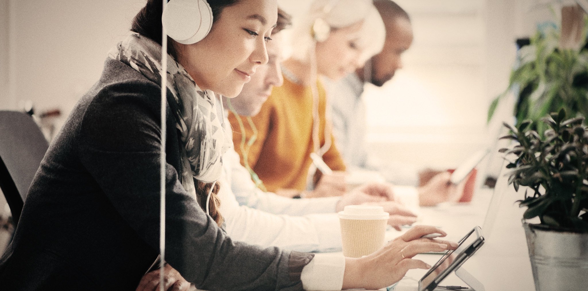 A group of people with tablets and headphones