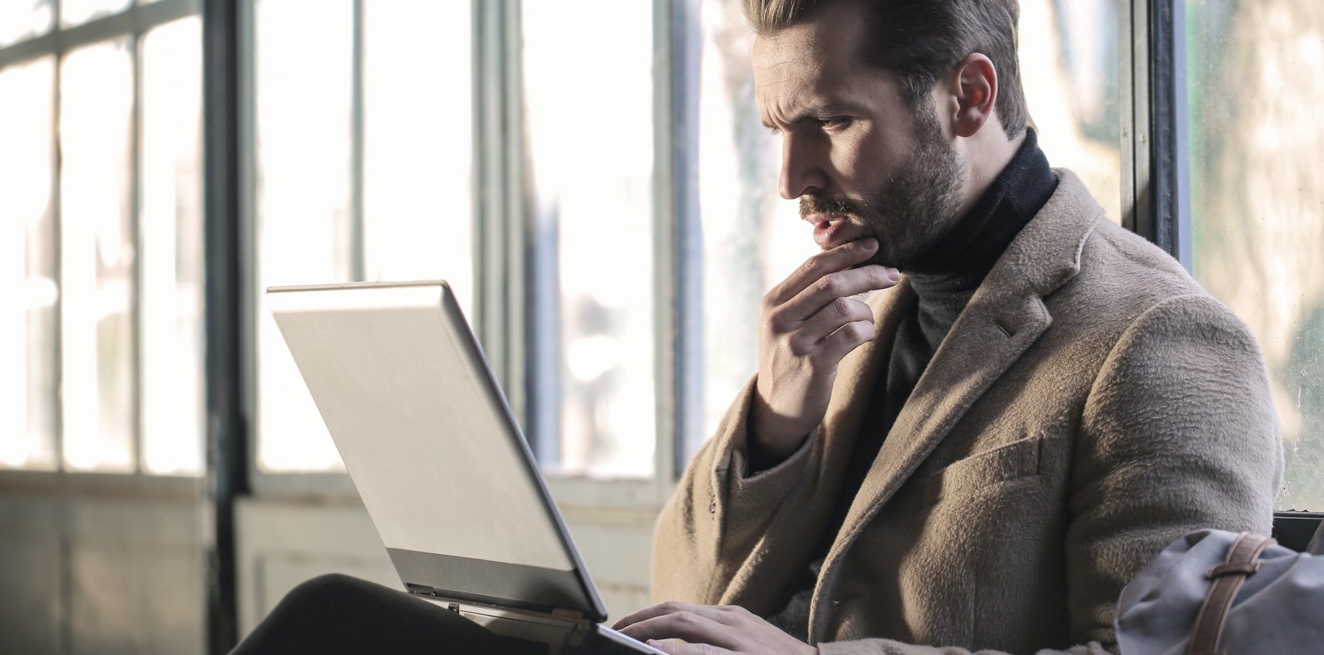 Man thinking in front of laptop 