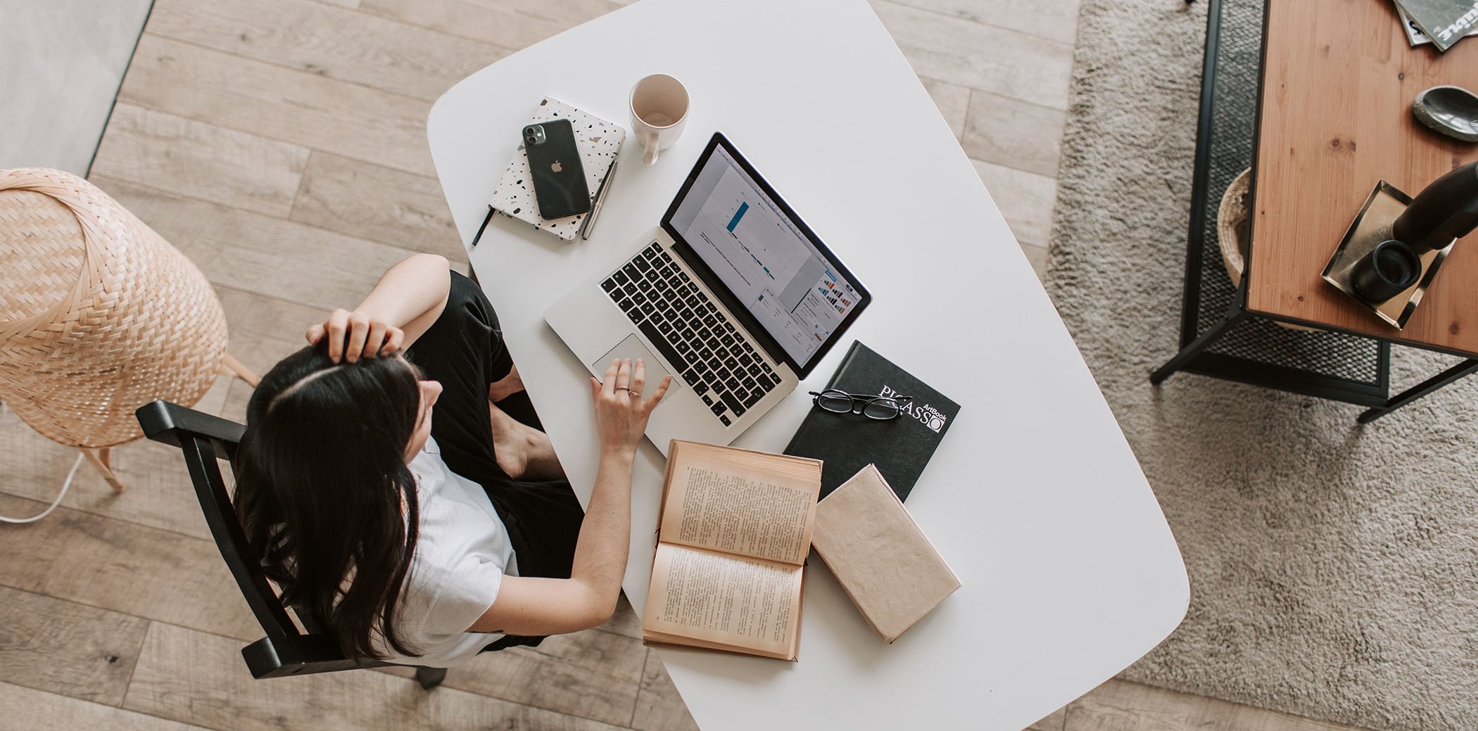 Woman with a laptop, a couple of books and a notebook