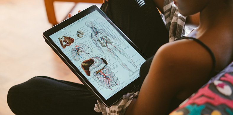 A girl looking at anatomical models on a tablet