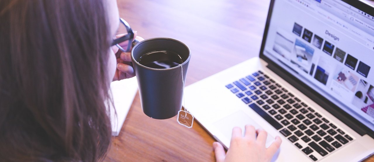 Mujer tomándose una taza de té mientras aprende en línea