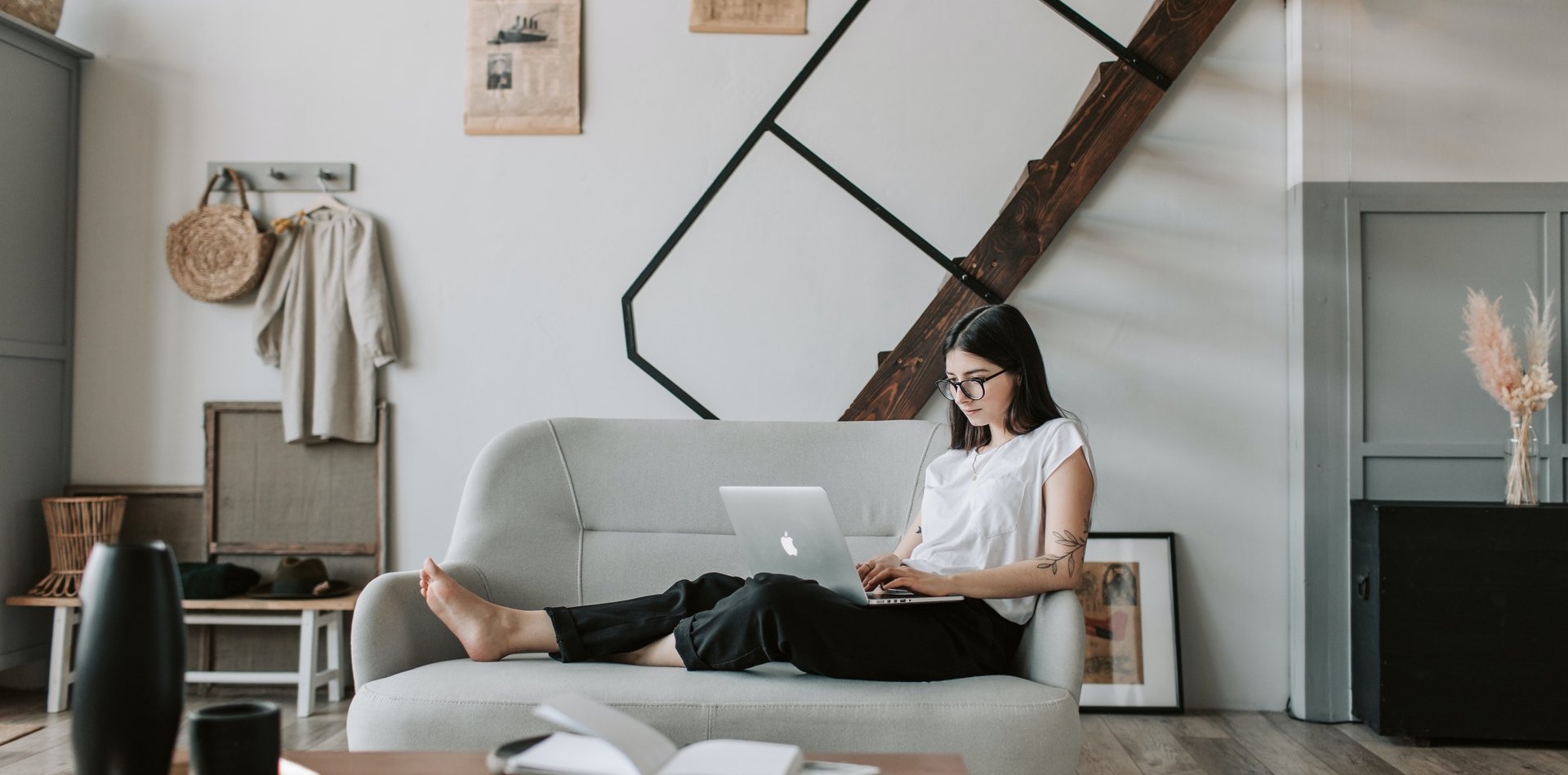 Woman lying on sofa with computer on legs