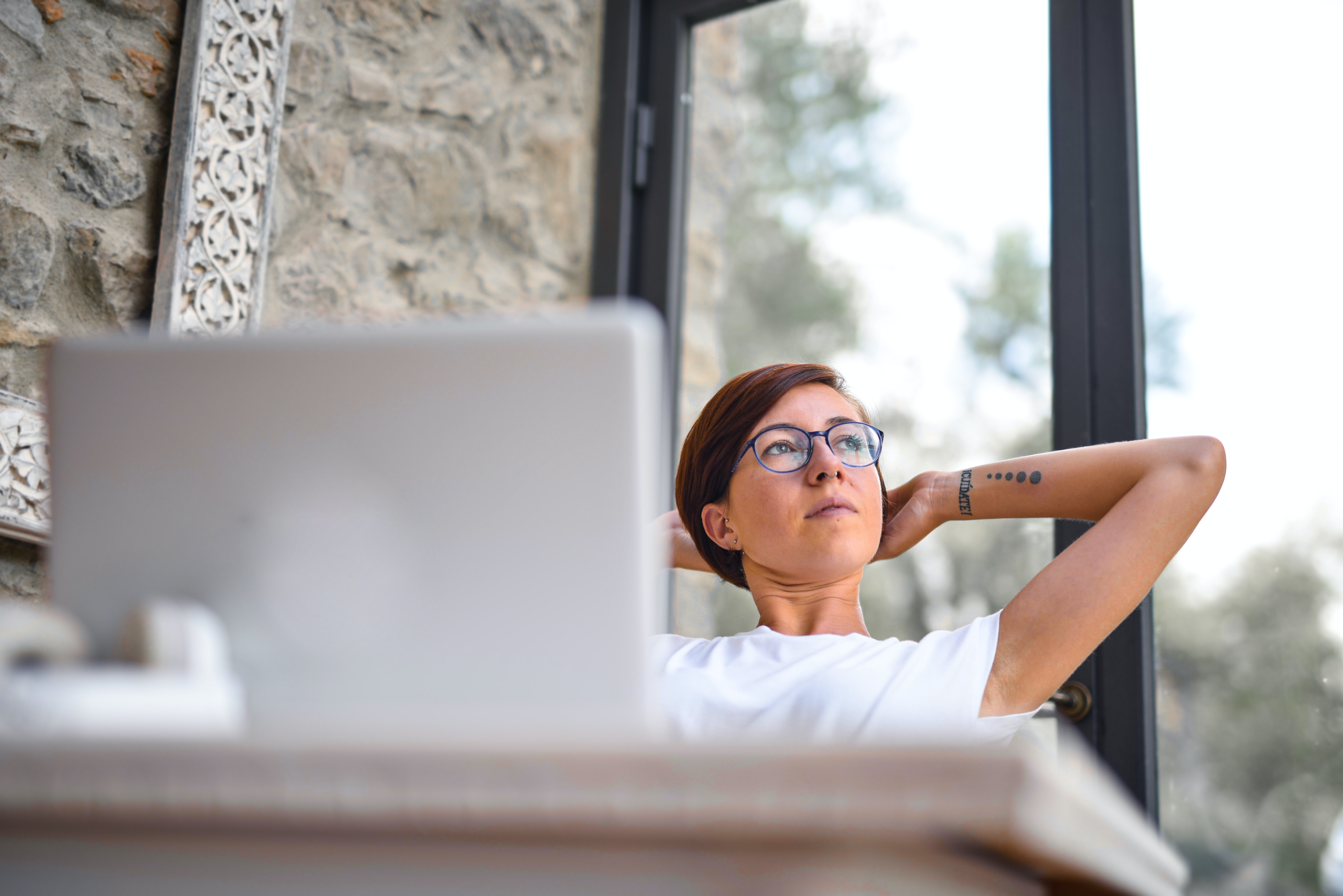 Woman thinking in front of a laptop